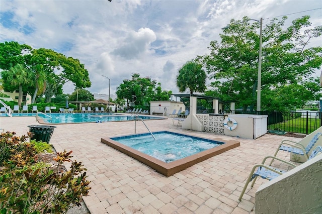 view of swimming pool with a community hot tub and a patio area