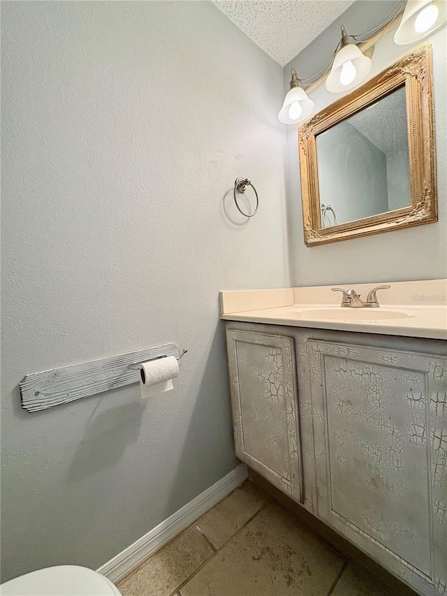 bathroom featuring vanity, tile patterned floors, and a textured ceiling