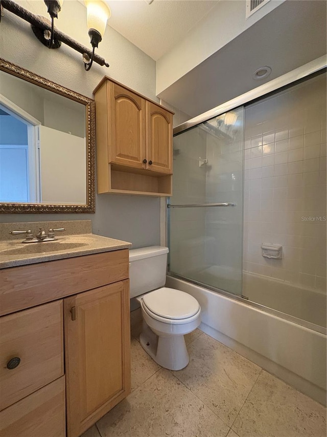 full bathroom featuring enclosed tub / shower combo, vanity, and toilet