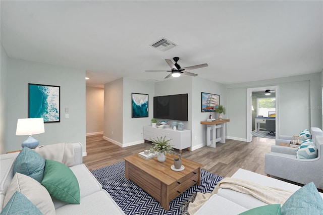 living room featuring ceiling fan and light hardwood / wood-style floors