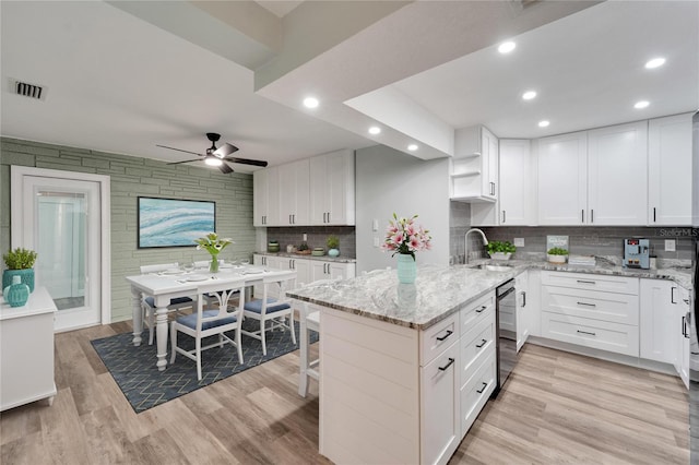 kitchen featuring sink, light hardwood / wood-style flooring, dishwasher, and white cabinets