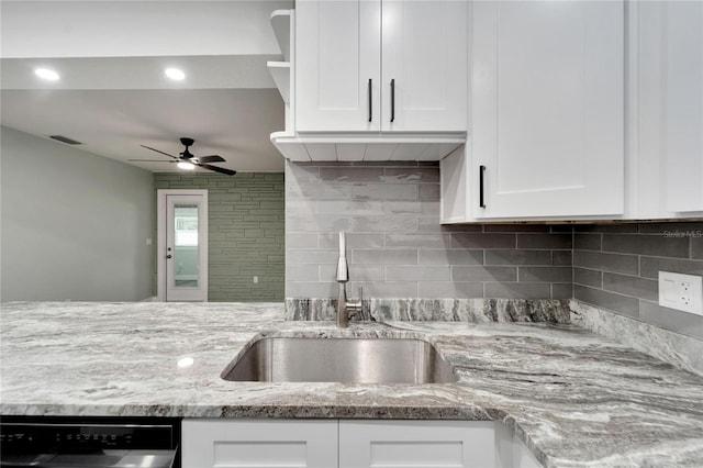 kitchen featuring white cabinetry, dishwashing machine, and sink