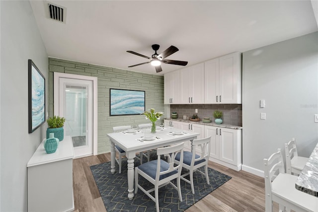 kitchen with ceiling fan, white cabinets, backsplash, and light hardwood / wood-style flooring