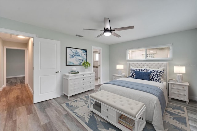 bedroom featuring ceiling fan, light wood-type flooring, and ensuite bath