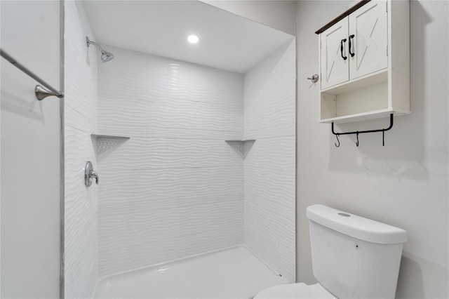 bathroom with tiled shower and toilet