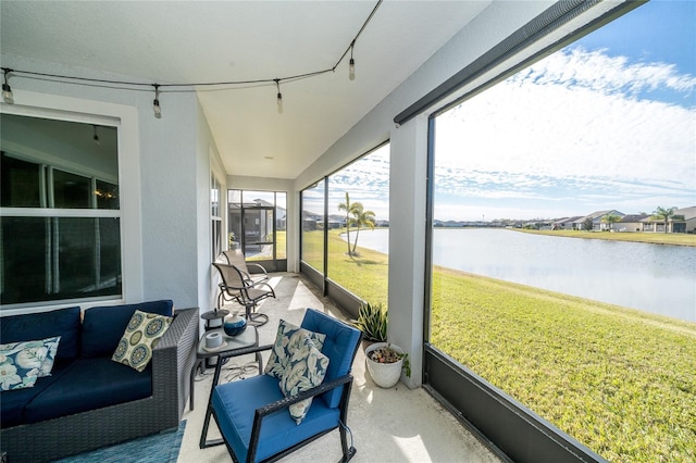 sunroom featuring a water view