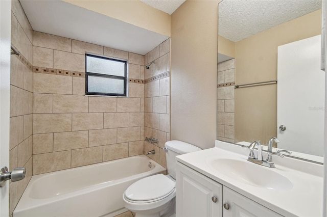 full bathroom featuring vanity, toilet, tiled shower / bath combo, and a textured ceiling