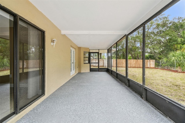 unfurnished sunroom featuring beamed ceiling