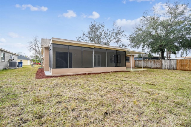 back of property featuring cooling unit, a lawn, and a sunroom