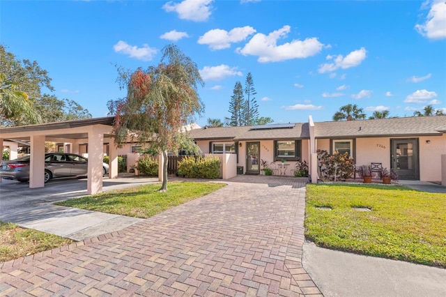 ranch-style house with a front lawn and a carport