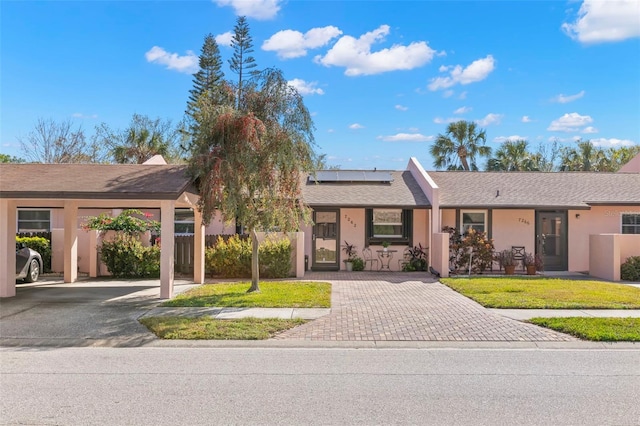 ranch-style home featuring a front yard, solar panels, and a porch