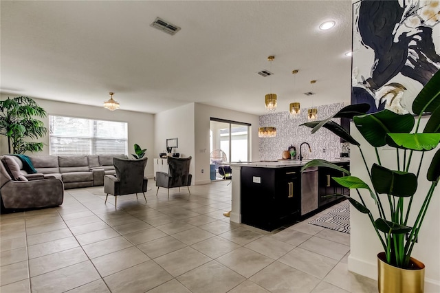 kitchen with hanging light fixtures, light tile patterned flooring, and a healthy amount of sunlight