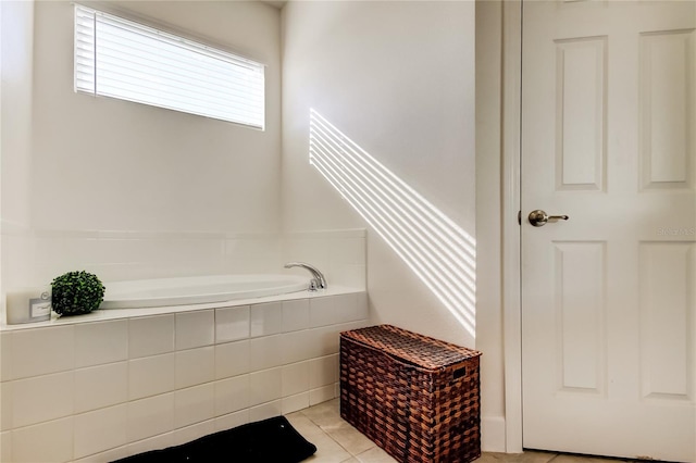 bathroom with a relaxing tiled tub and tile patterned flooring