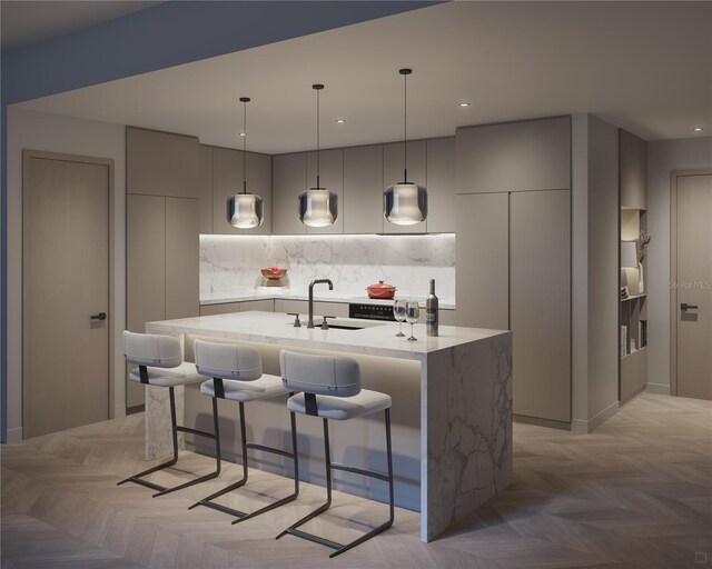 kitchen with tasteful backsplash, a center island with sink, and light parquet floors