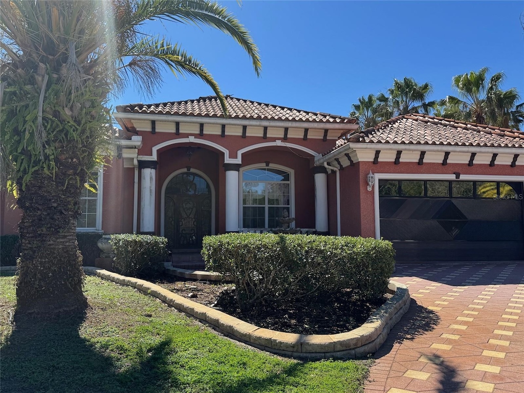 mediterranean / spanish home featuring a garage