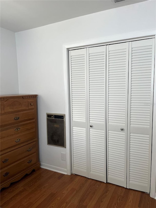 unfurnished bedroom featuring dark hardwood / wood-style floors and a closet