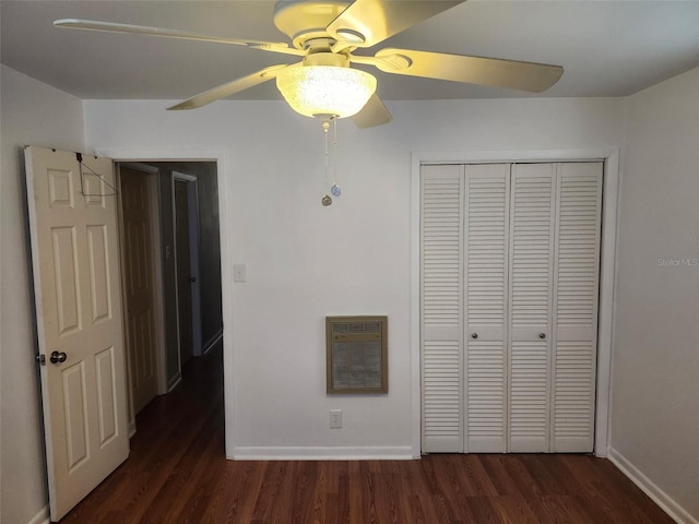 unfurnished bedroom featuring dark hardwood / wood-style flooring, heating unit, a closet, and ceiling fan