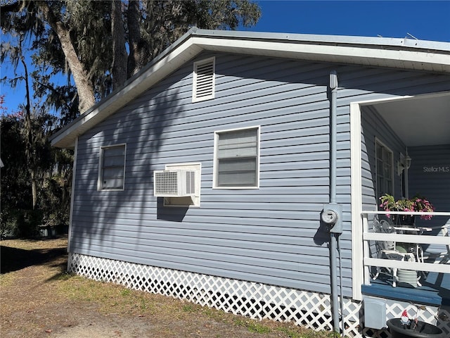 view of side of property with a wall mounted air conditioner