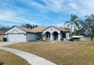 ranch-style house with a garage and a front lawn