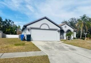 ranch-style home with a garage and a front lawn