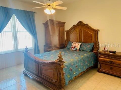 tiled bedroom featuring ceiling fan