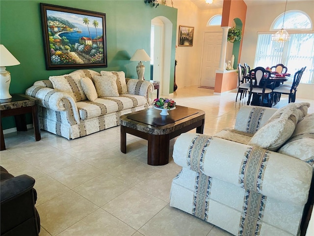 living room with a chandelier, arched walkways, and light tile patterned flooring