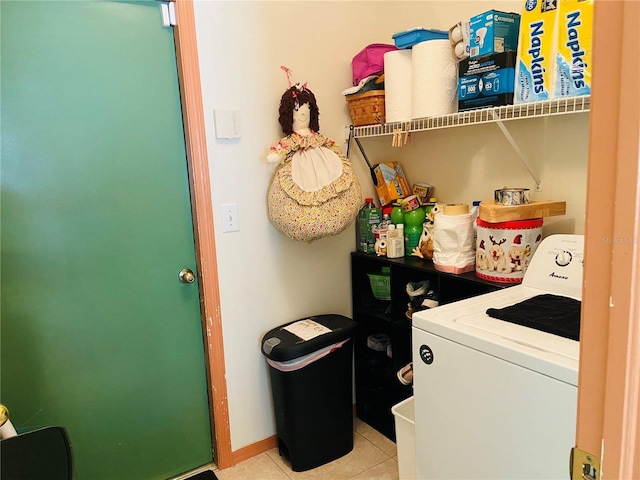 clothes washing area featuring laundry area, light tile patterned floors, and washer / clothes dryer