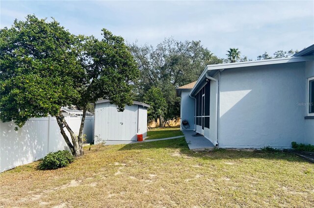 view of yard with an outbuilding, a shed, and fence