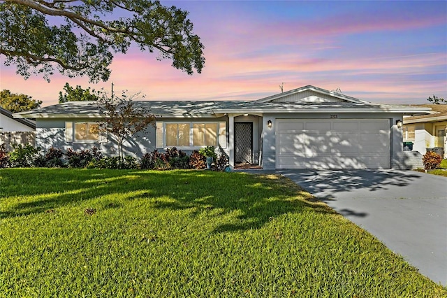 ranch-style home featuring a yard and a garage