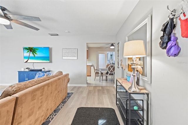 living room featuring ceiling fan and light wood-type flooring