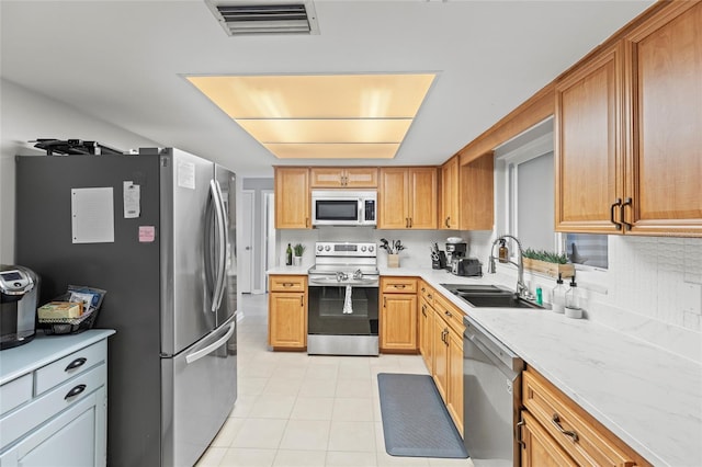 kitchen featuring sink, backsplash, stainless steel appliances, and light tile patterned flooring