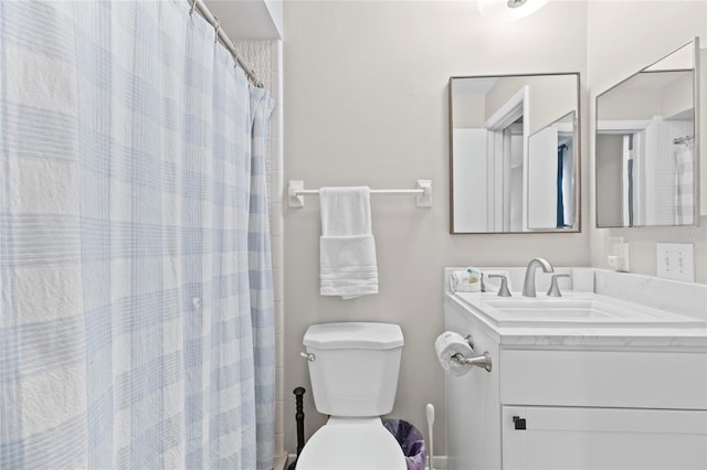 bathroom featuring vanity, curtained shower, and toilet