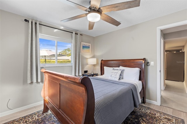 bedroom featuring a textured ceiling, wood-type flooring, stainless steel fridge, and ceiling fan