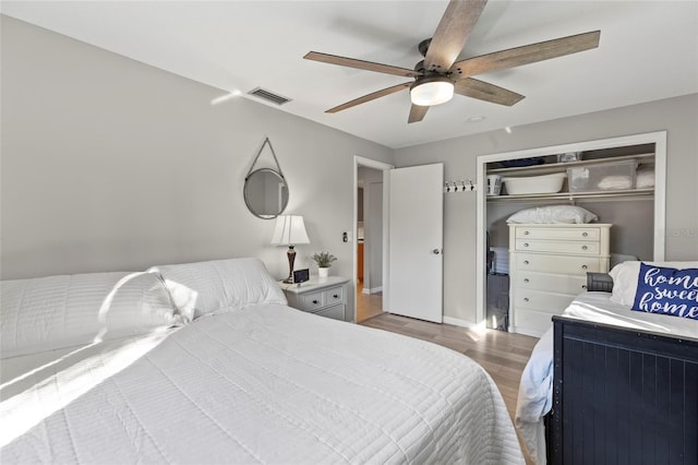 bedroom featuring ceiling fan, a closet, and light wood-type flooring