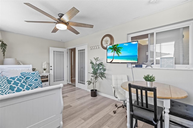 bedroom featuring ceiling fan, light hardwood / wood-style flooring, and a textured ceiling