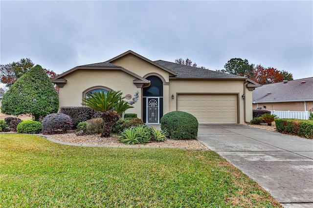 single story home with a garage and a front lawn