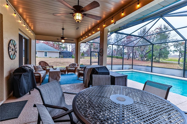 view of patio with ceiling fan, outdoor lounge area, area for grilling, and glass enclosure