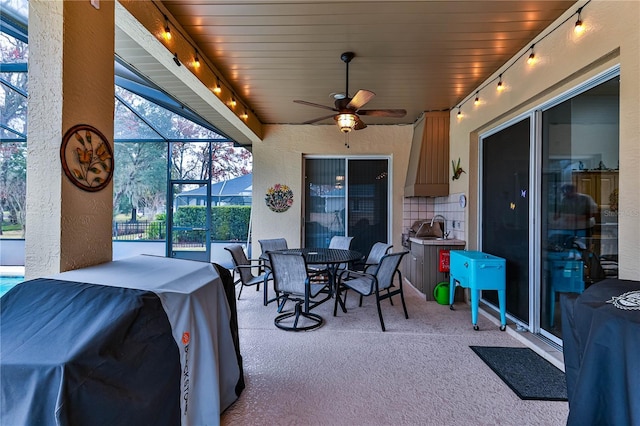 view of patio / terrace featuring grilling area, ceiling fan, and glass enclosure