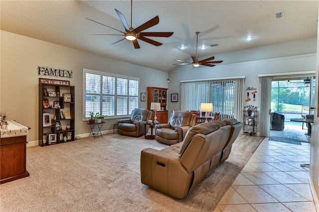 living room with ceiling fan, vaulted ceiling, a textured ceiling, and light tile patterned floors