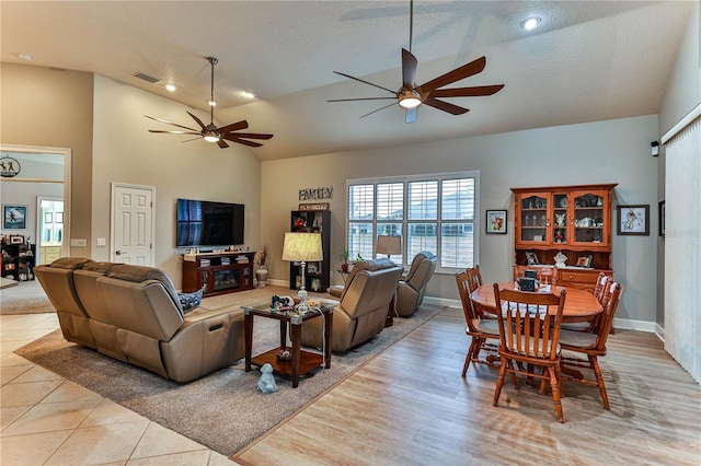 living room featuring ceiling fan, lofted ceiling, and a textured ceiling