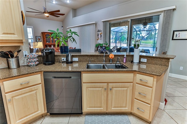 kitchen with vaulted ceiling, dishwasher, sink, dark stone countertops, and kitchen peninsula