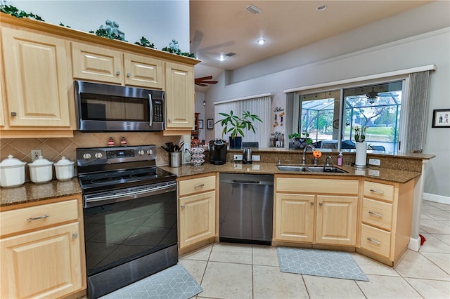 kitchen featuring sink, light tile patterned floors, black appliances, and kitchen peninsula