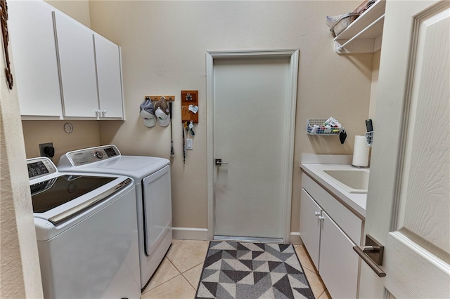 laundry room featuring cabinets, sink, washing machine and dryer, and light tile patterned floors