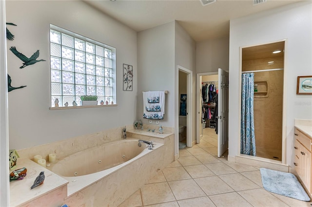 full bathroom with tile patterned flooring, vanity, shower with separate bathtub, and toilet