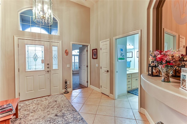 tiled entryway featuring a high ceiling and a notable chandelier