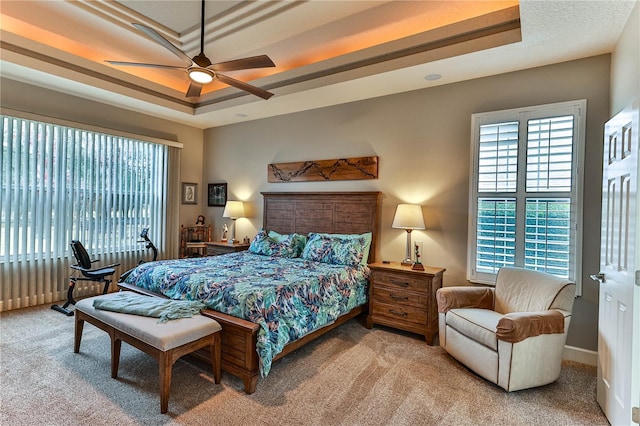 bedroom with ceiling fan, a raised ceiling, and carpet floors