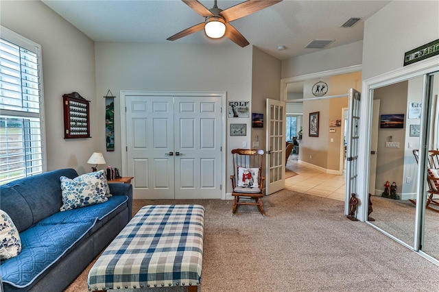 carpeted living room with ceiling fan and french doors