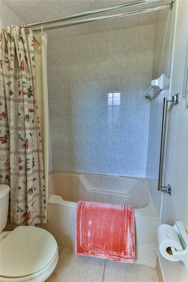 bathroom featuring tile patterned flooring, shower / tub combo, and toilet