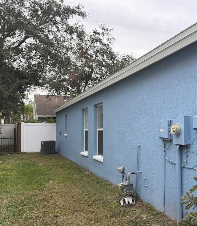 view of property exterior with a yard and central AC