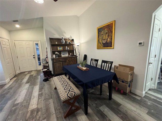 dining space featuring lofted ceiling and dark wood-type flooring